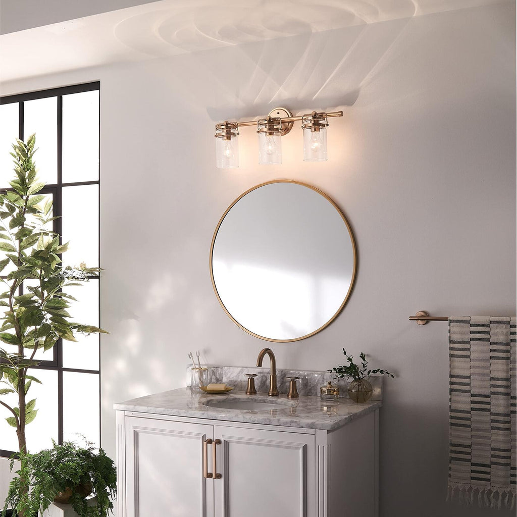 Kichler, Brinley 24" 3 Light Vanity Light with Clear Glass in Champagne Bronze,